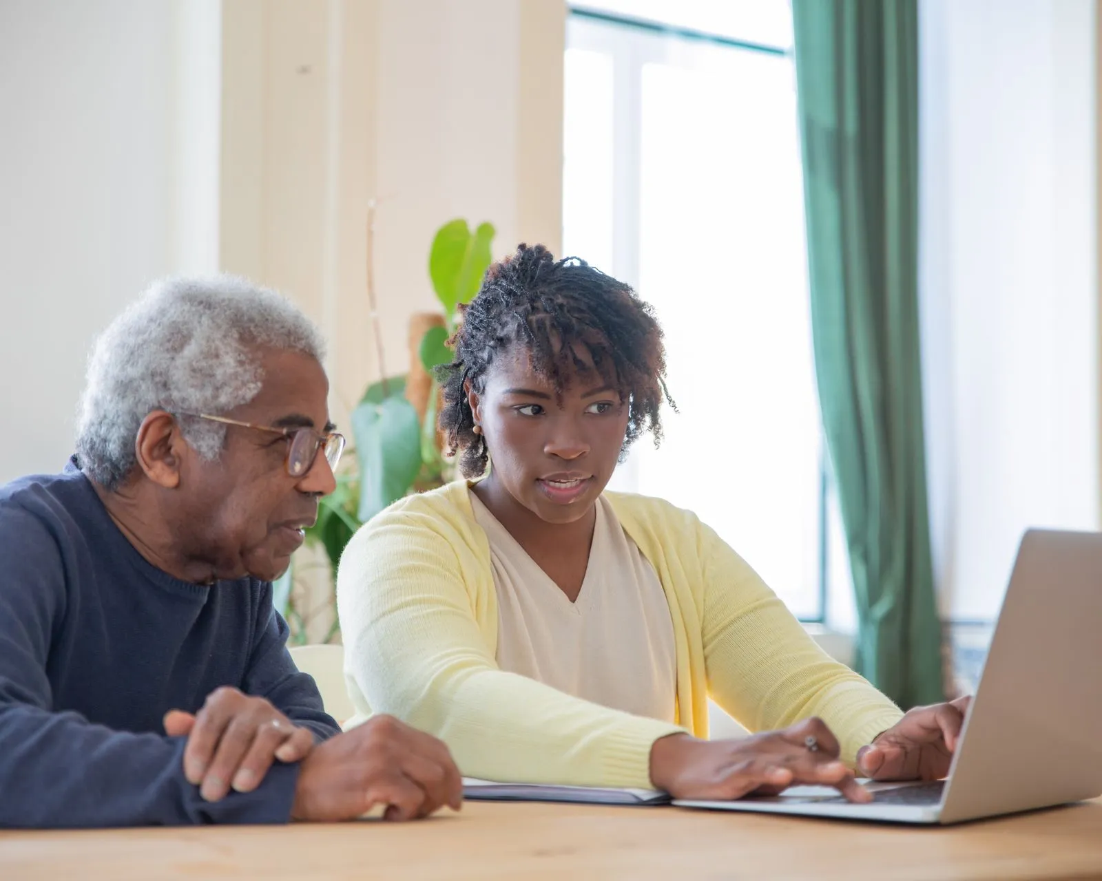 Care coordinator and older adult reviewing information together on a laptop at a table